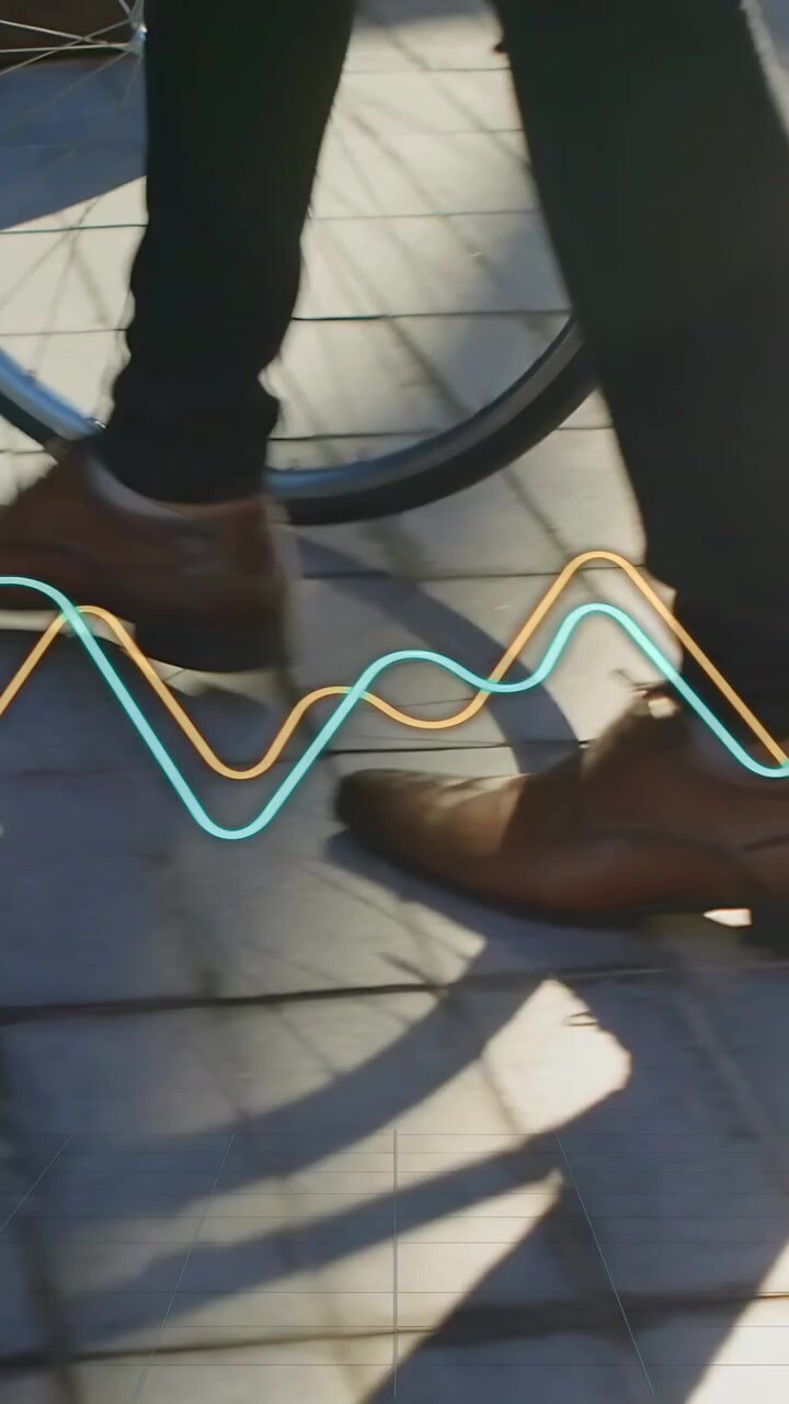 Vertical video: Man stepping past bicycle on tiles during commute waveform crossing shoe shadow
