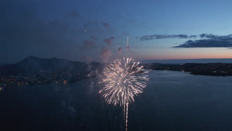 beautiful aerial shot of fireworks over bergen, norway just after sunset