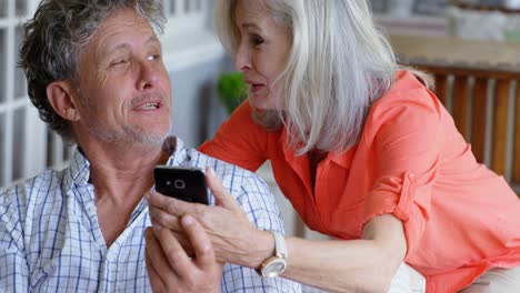 senior couple using mobile phone on the porch 4k