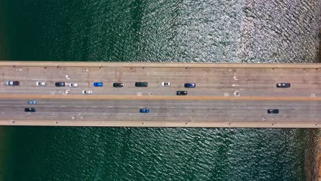 Vista-Aérea-Timelapse-Del-Paso-Elevado-De-La-Autopista-De-San-Diego-Con-Agua-Del-Océano-Debajo-Y-Tráfico-Que-Pasa