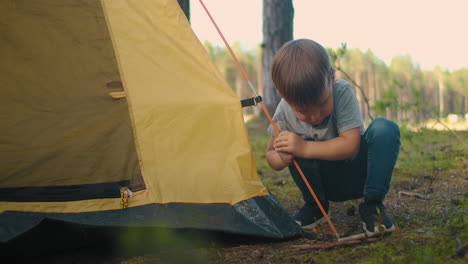 manik 3 years learns to set up a tent in a campaign