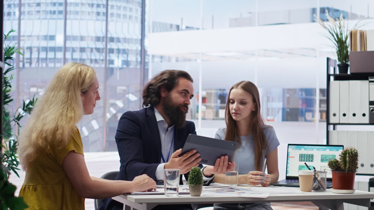 Agent in office assisting mother and daughter with investment portfolio