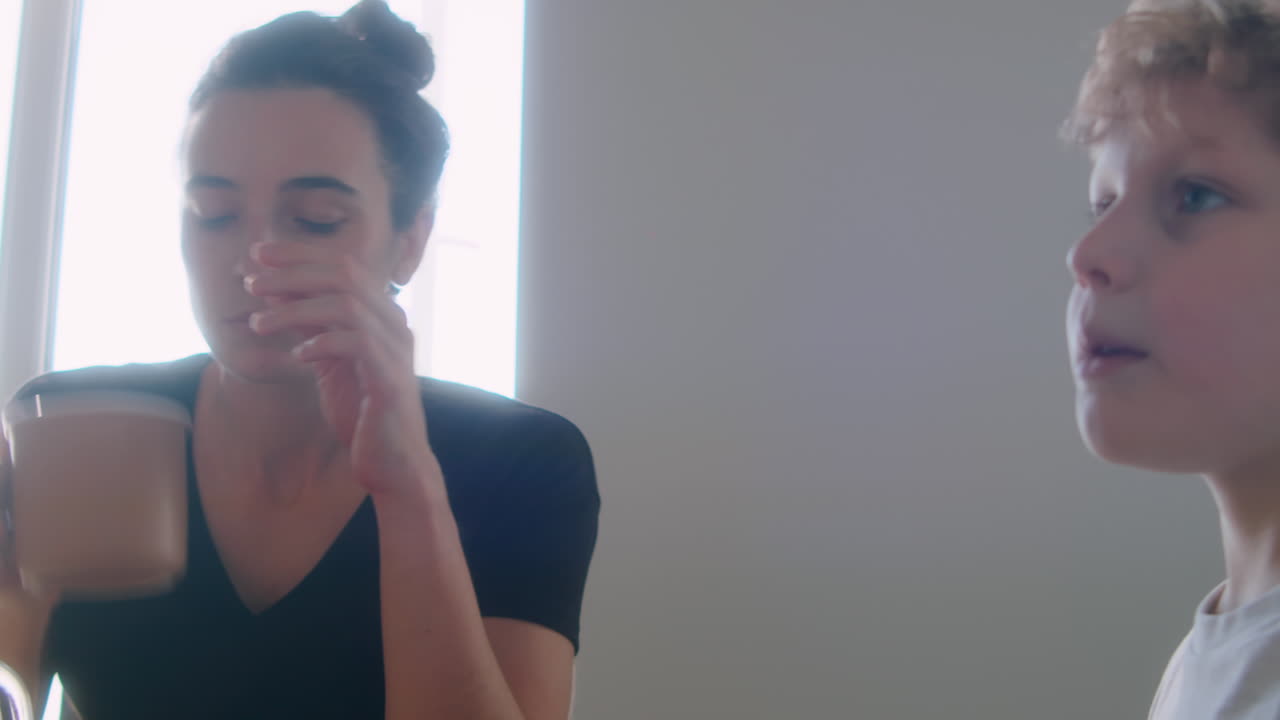 Little Boy Chatting with Lesbian Mothers during Meal at Home