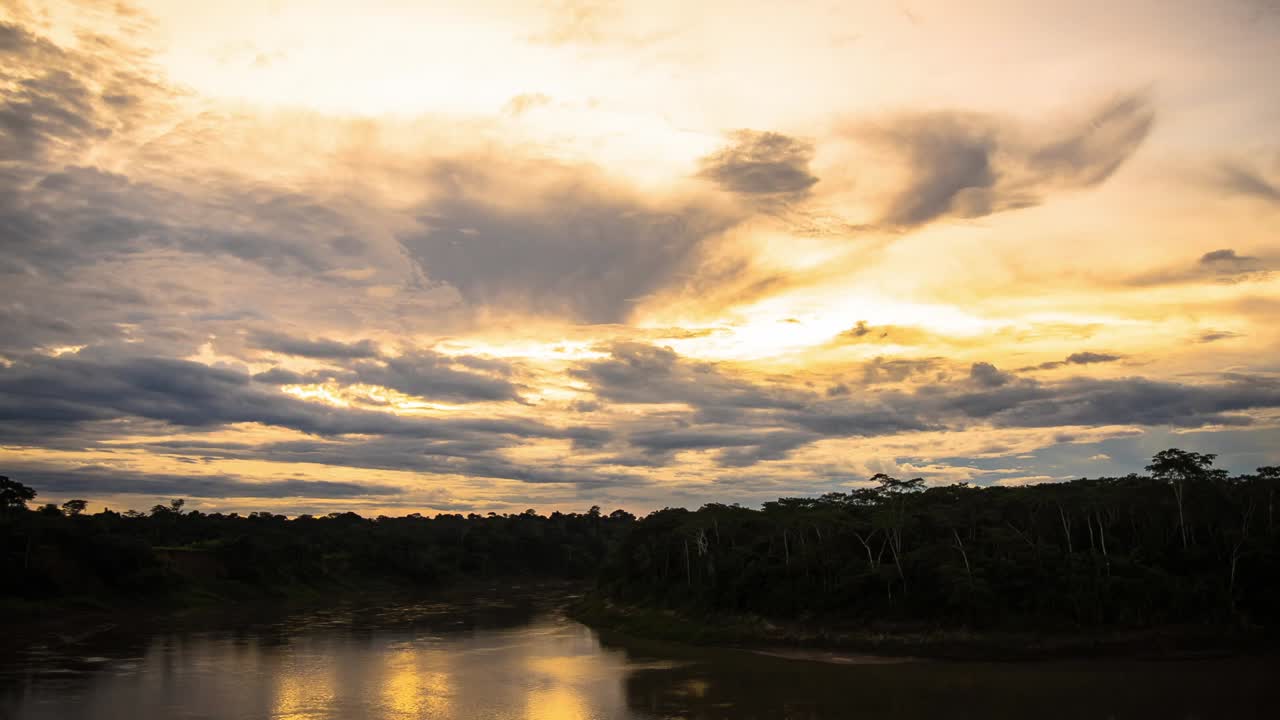 espectacular lapso de tiempo de día a noche desde la puesta de sol sobre el río tambopata hasta la puesta de la luna en el cielo nocturno con elementos de colores cambiantes sobre el cielo del bosque, perú