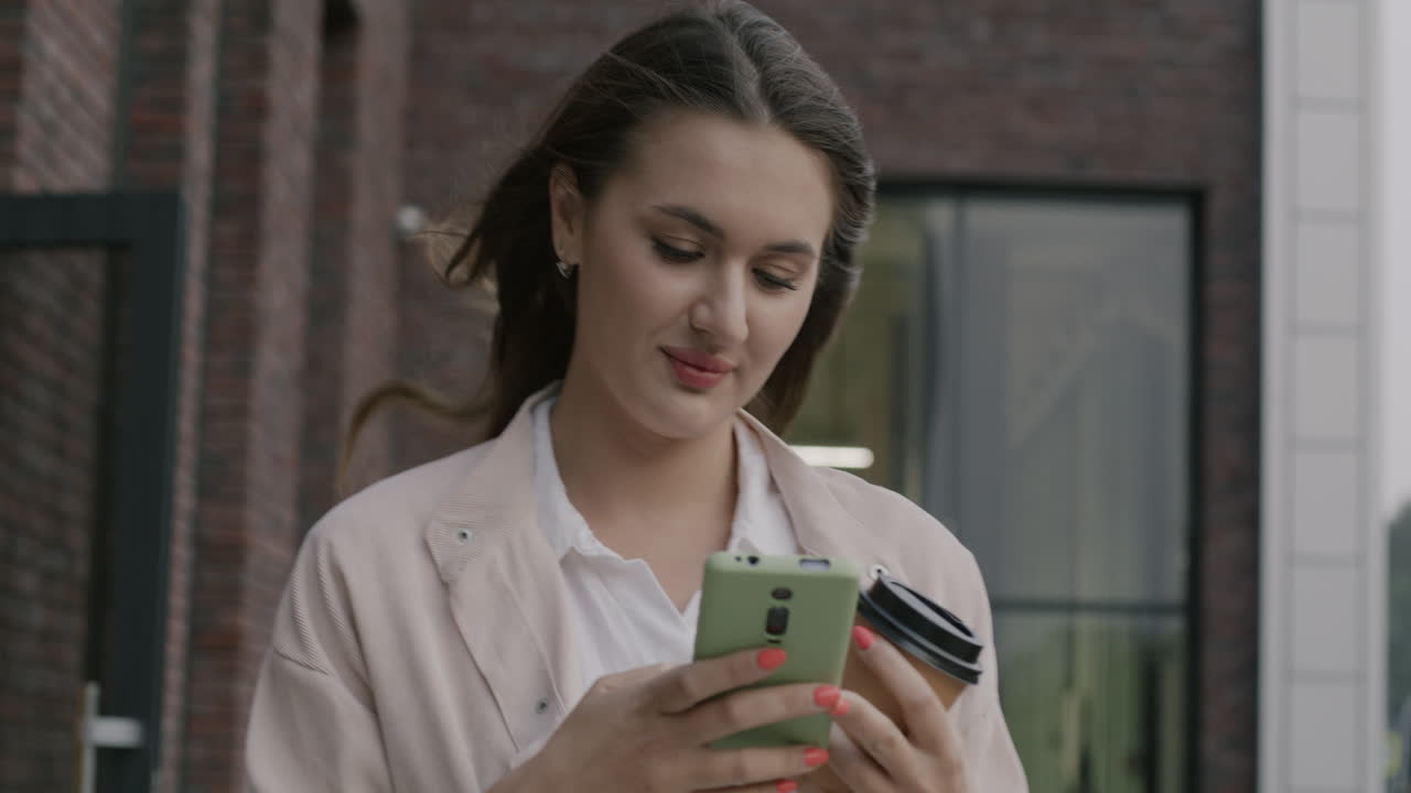 Woman Walking in City, Using Smartphone and Coffee