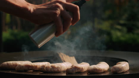 man preparing bbq sausages outside