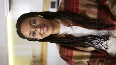 Portrait-beautiful-african-american-woman-with-dreadlocks-smiling-looking-happy-feeling-confident,-wearing-earphones