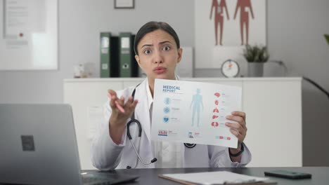 angry indian female doctor explaining medical report to patient