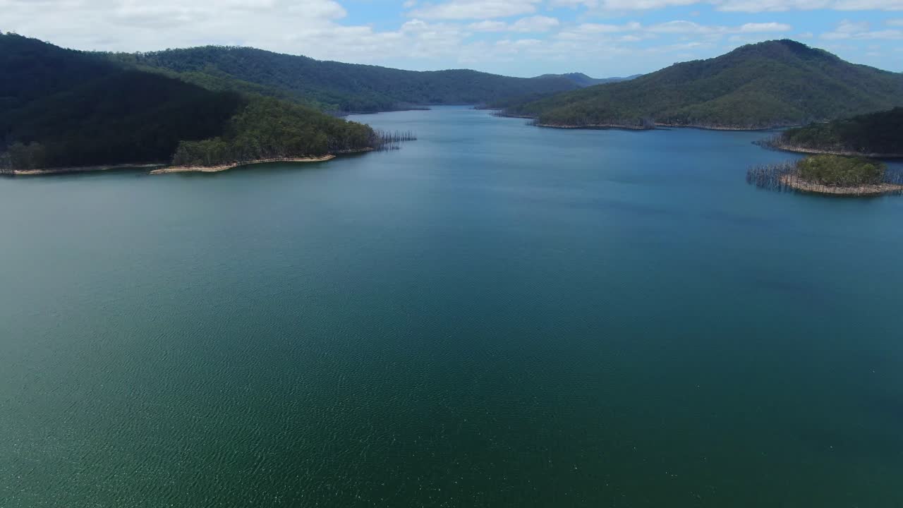 Flying forward, panorama of Advancetown Lake on a clear summers day.Gold Coast