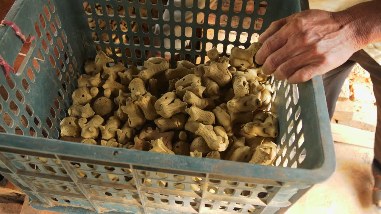 imágenes de arriba hacia abajo de un hombre asiático colocando arcilla en forma de animal en un horno de leña para disparar, mostrando recuerdos turísticos tradicionales en thanh ha
