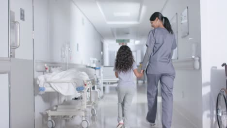 Enfermera-Diversa-Y-Paciente-Infantil-Caminando-Por-El-Pasillo-Del-Hospital,-En-Cámara-Lenta