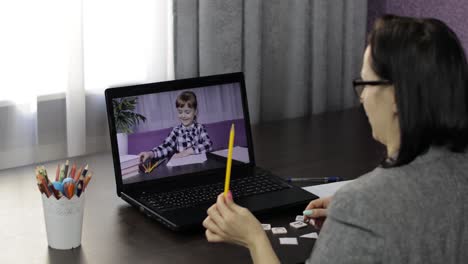 woman teacher making video call on laptop with little pupil. distance education