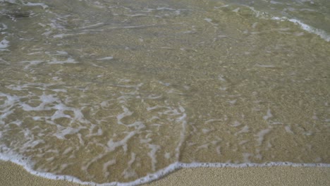 Sandy-beach-of-an-island-with-small-wave-rolling-into-frame,-tropical-Fiji