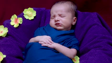 lindo bebé recién nacido durmiendo en una envoltura de bebé con flores en un estilo único desde el ángulo superior