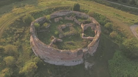 drone orbit around old round structure in decay - ruins