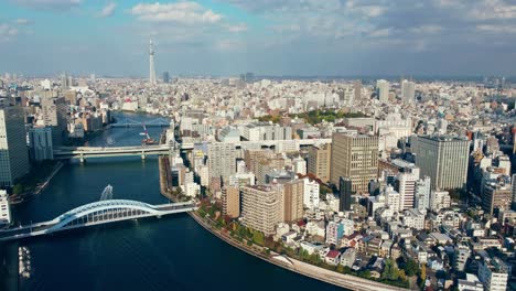 Drone-Aéreo-Volando-Sobre-El-Río-En-La-Ciudad-De-Tokio-Japón-Con-Tokyo-Skytree-En-El-Fondo