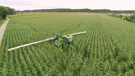 pulverizador moviéndose a través del campo de maíz, aplicando protección de cultivos
