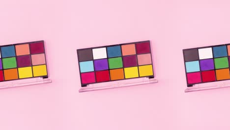las paletas de sombras de ojos con muchos colores diferentes giran sobre un tema rosa brillante.