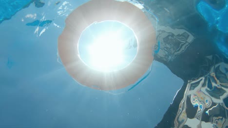 life preserver floating in a clear pool water, slow motion, underwater view