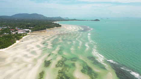 aerial flying over white sands and turquoise waters of nathon town, koh samui