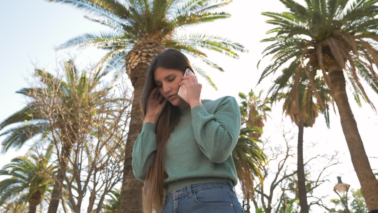 mujer joven preocupada hablando por teléfono en la calle en un día soleado