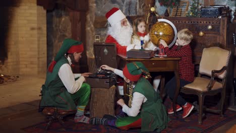 christmas celebration with santa claus. santa explaining little girl something new