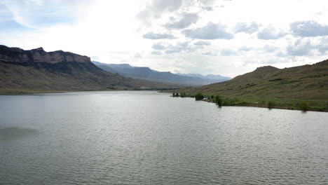 panoramic view of a serene mountain lake under a cloudy sky