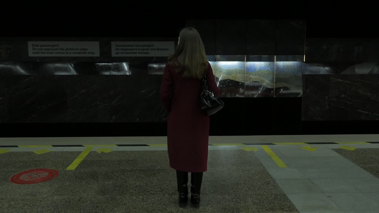 역 에서 지하철 열차 를 기다리는 여자