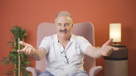 old man making heart sign at camera.