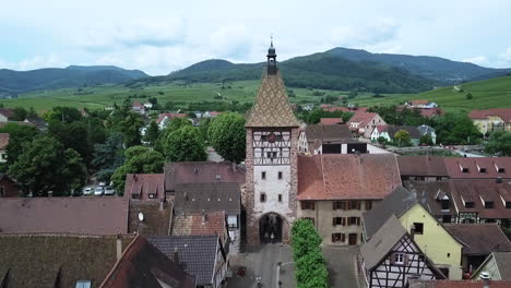 luftaufnahme über der grand rue mit nach oben geneigter sicht auf die porte haute und hügelige grüne landschaften in der ferne