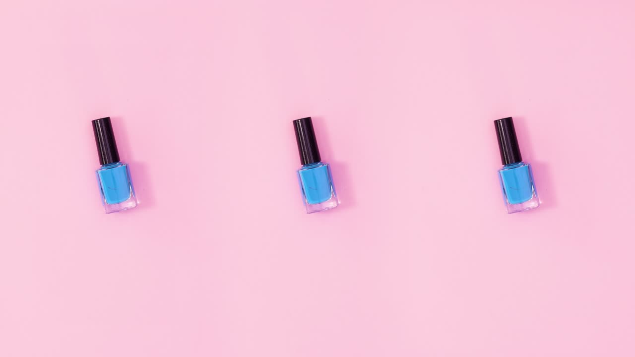 Tre neglelakflasker roterer på pastelrosa baggrund. Stop-motion.