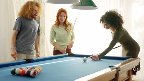 Woman applauding a friend while playing pool