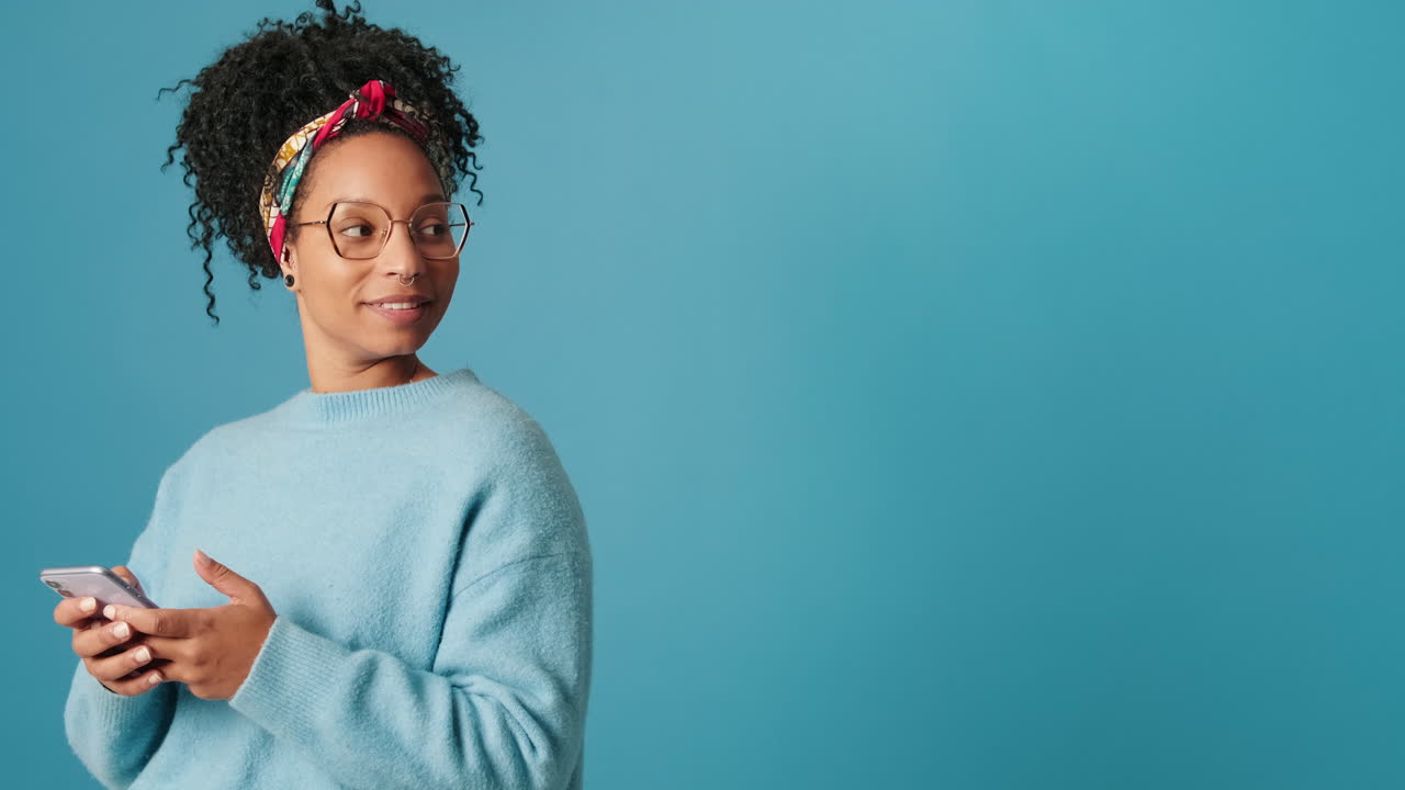 Young African American Woman Smiling While Using Smartphone