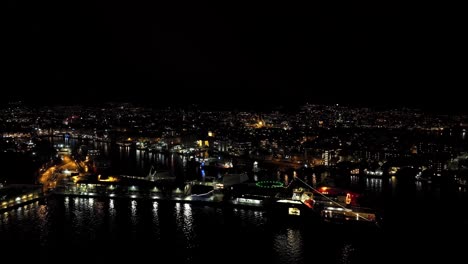 smaller private fireworks launched throughout the city of bergen during new year celebration - aerial from the harbor and city fjord