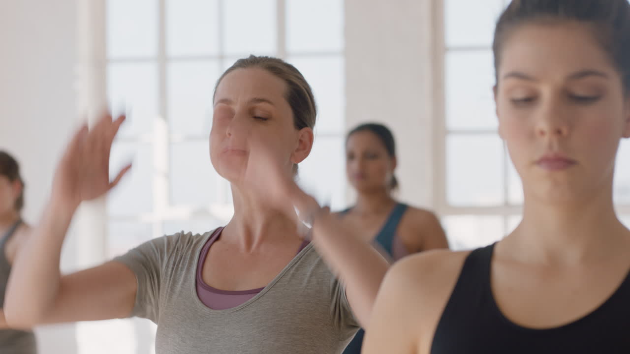 retrato de clase de yoga joven mujer embarazada caucásica practicando poses sosteniendo el vientre disfrutando de ejercicio grupal en el gimnasio