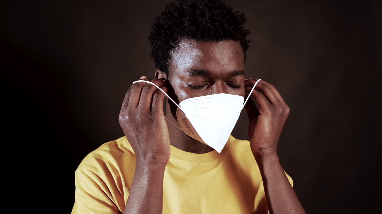 Young Black Man Putting On N95 Face Mask For Coronavirus Protection