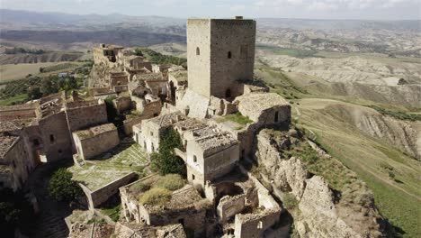 Drone-Volando-En-Gran-Movimiento-Circular-Cerca-De-Las-Antiguas-Ruinas-De-Craco-En-Una-Colina-En-El-Sur-De-Italia-En-4k