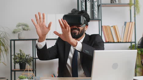 young business man in vr goggles watch virtual reality video, working on simulation game at office