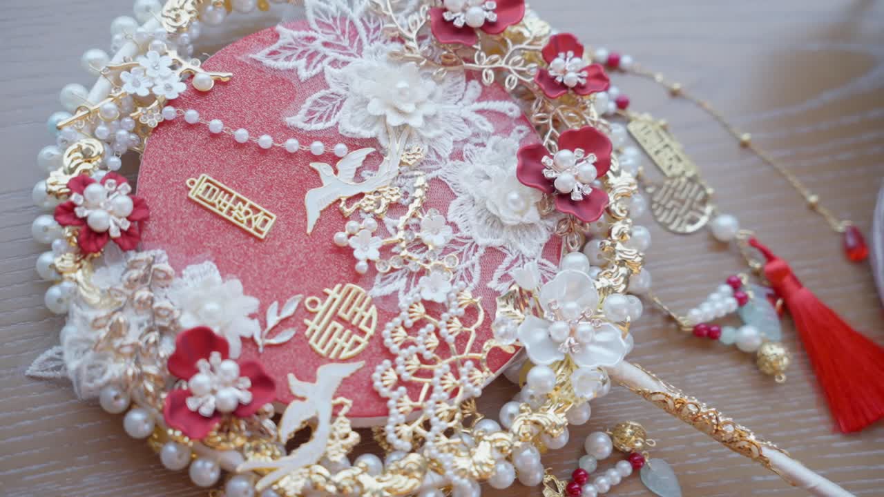 Opulent Chinese bridal fan with pearls, lace, and gold symbols