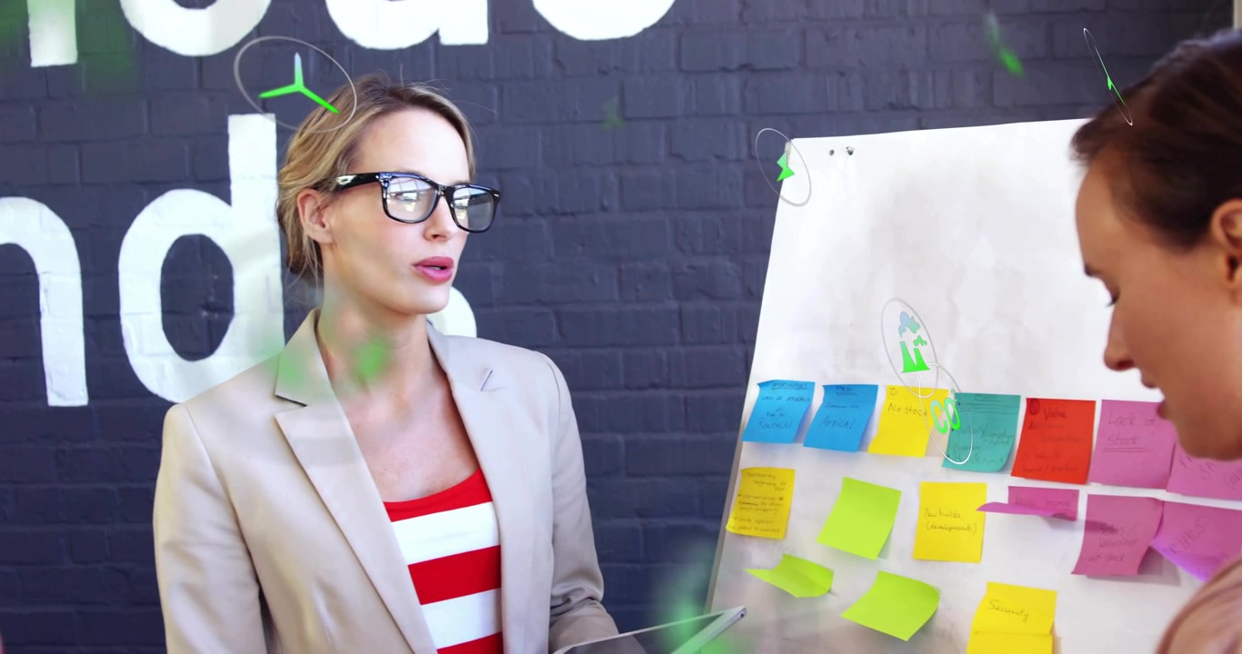 Presenter pointing sticky note while tapping tablet activating icons in business brainstorming