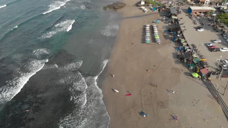 aerial view of people surfing and relaxing on a tropical beach