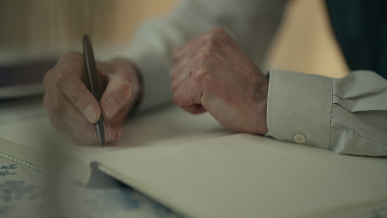 Primo piano di mani adulte che scrivono appunti su un quaderno