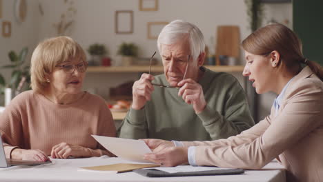 female financial advisor consulting senior couple at home