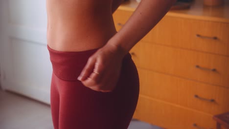 attractive flat stomach woman wearing red yoga pants and ready for workout