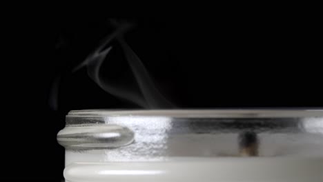 watch the beautiful moment of a candle flame slowly extinguishing in the dark.