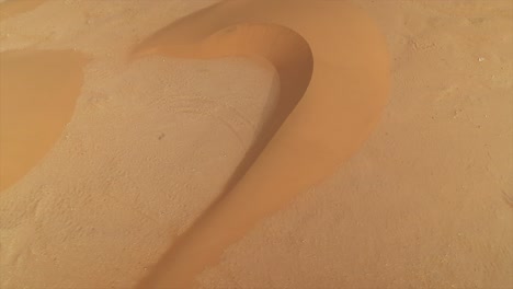 aerial footage of wind-sculpted sand dune patterns and textures in el agunia, morocco, africa, nature background. drone top-down view