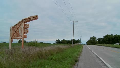 un gran cartel amarillo apunta a higginsville missouri desde un campo agrícola 2