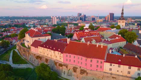 Drone ascending backwards over colorful old town Tallinn Estonia, showcasing Kiek in de Kok defensive towers