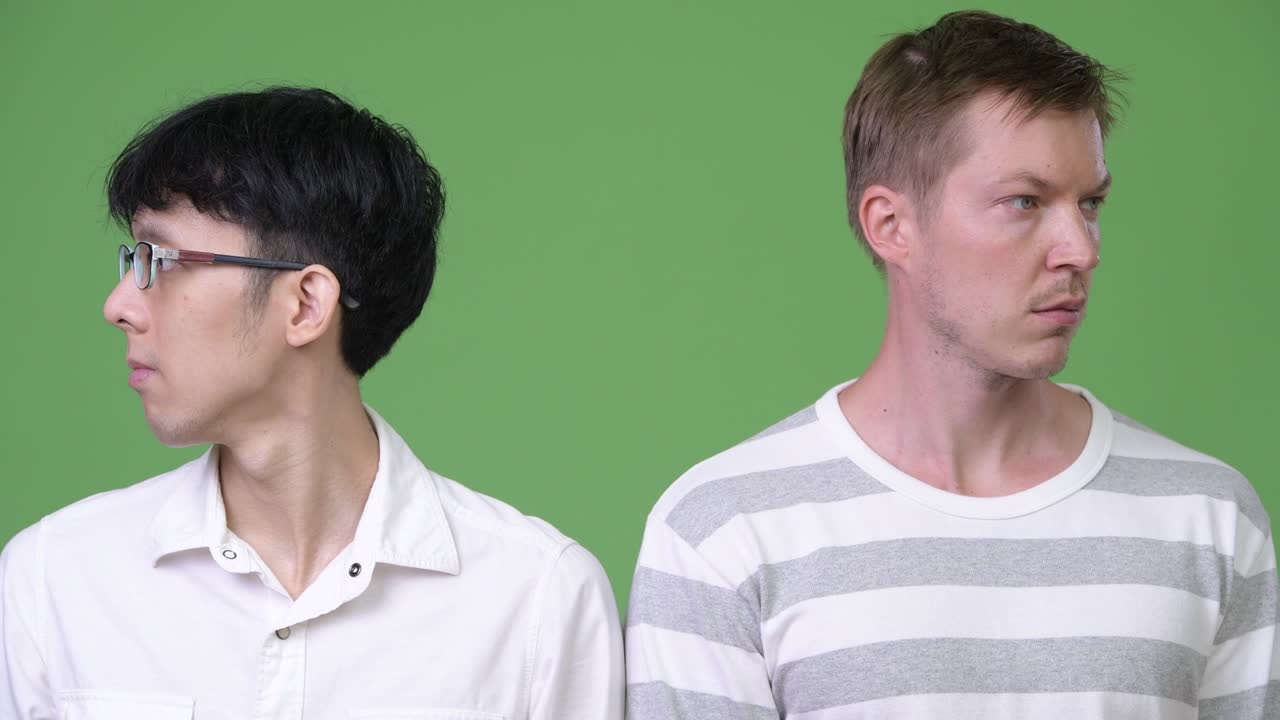 두 명의 젊은 다민족 사업가들이 서로 반대 방향을 바라보고 있습니다.