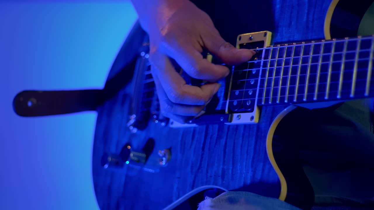 primer plano de la mano del músico tocando la guitarra eléctrica